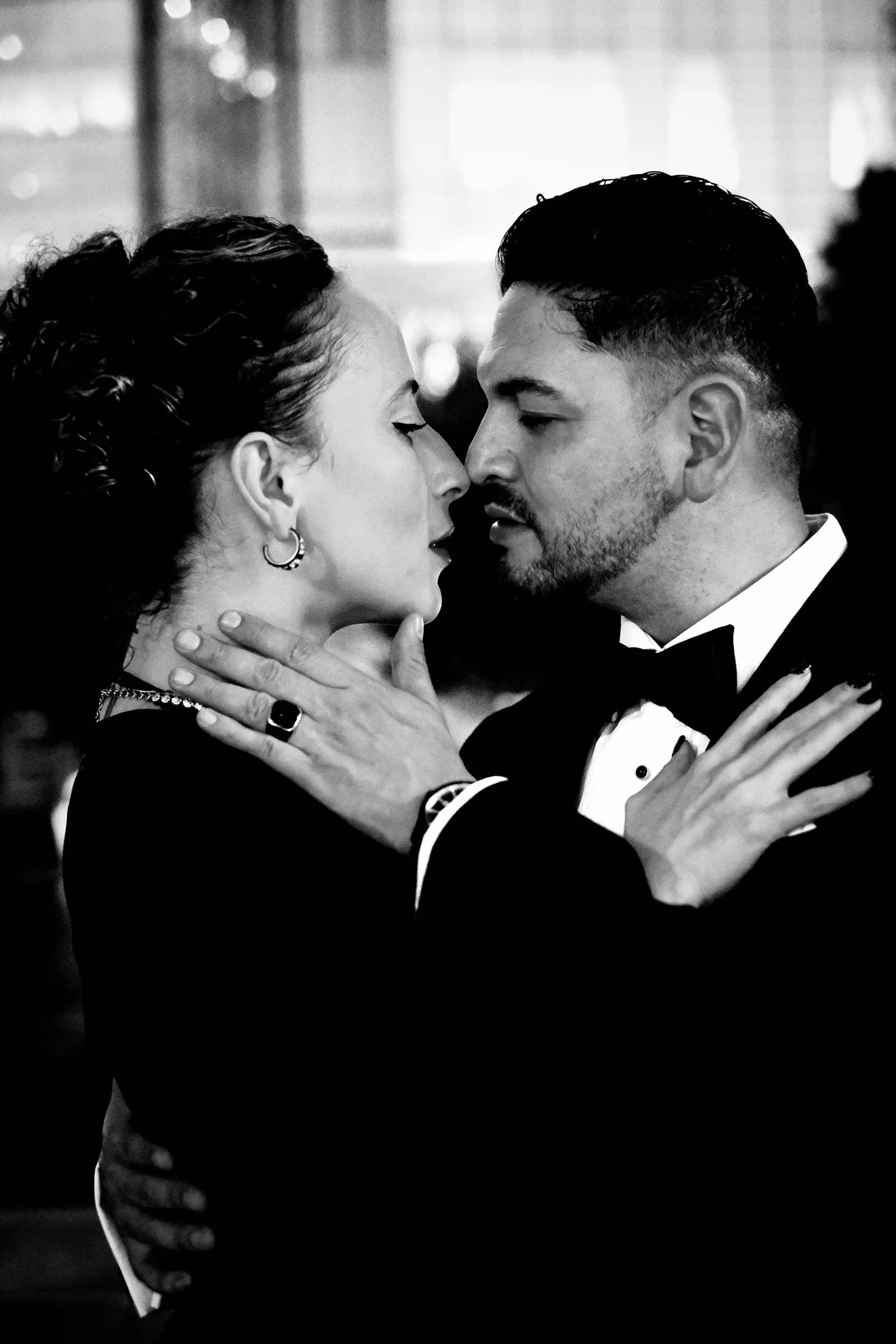 Close black and white portrait of a couple a breath apart on the dance floor, her hand at his neck